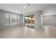 A spacious and brightly-lit living room features tile floors, light gray walls, and a glass slider leading to a covered patio at 7691 W Cactus Wren Way, Florence, AZ 85132