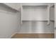 A simple walk-in closet features carpeted flooring, white shelving, and clothes racks for organized storage and space efficiency at 7691 W Cactus Wren Way, Florence, AZ 85132