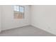 View of bedroom with neutral carpet, paint and large window at 12333 W Marguerite Ave, Avondale, AZ 85323