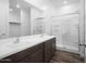 Bright bathroom featuring double sink vanity, a large mirror, and a glass enclosed walk-in shower at 24629 W St Catherine Ave, Buckeye, AZ 85326