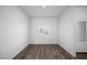 A bedroom featuring wood flooring, a window, and white walls, creating a simple, clean space at 24629 W St Catherine Ave, Buckeye, AZ 85326