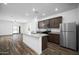 Modern kitchen boasts stainless steel appliances, granite counters, wood floors, and recessed lighting at 24629 W St Catherine Ave, Buckeye, AZ 85326