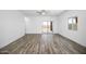 Large living space featuring wood flooring, a ceiling fan, and sliding glass doors leading to the patio at 24629 W St Catherine Ave, Buckeye, AZ 85326