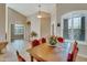 Spacious dining room with a wooden table and red chairs at 9612 E Champagne Dr, Sun Lakes, AZ 85248