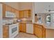 Kitchen features white appliances and wood cabinets at 9612 E Champagne Dr, Sun Lakes, AZ 85248