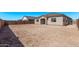 View of the backyard showing the home, empty lot, and block wall at 11949 W Parkway Ln, Avondale, AZ 85323