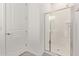 Bright bathroom featuring a glass door shower, a door, and neutral-toned walls at 11949 W Parkway Ln, Avondale, AZ 85323