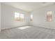 Bright bedroom featuring three large windows and neutral carpeting at 11949 W Parkway Ln, Avondale, AZ 85323