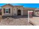 Charming single-story home with desert landscaping, arched entryway, and attached two-car garage at 11949 W Parkway Ln, Avondale, AZ 85323