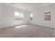 Bright bedroom featuring neutral carpet, large windows, and light walls at 12003 W Parkway Ln, Avondale, AZ 85323