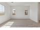 Well-lit bedroom featuring neutral carpet, light walls, and large windows at 12003 W Parkway Ln, Avondale, AZ 85323