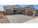 Inviting home featuring a spacious driveway, a two-car garage, and elegant stone detailing on the facade at 12003 W Parkway Ln, Avondale, AZ 85323
