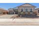 Charming single-story home showcasing a stone and stucco exterior with a well-manicured front yard at 12003 W Parkway Ln, Avondale, AZ 85323