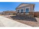 Charming home exterior with stone accents, complemented by a tidy gravel garden and well-lit windows at 12003 W Parkway Ln, Avondale, AZ 85323