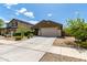 Inviting single-story home with a manicured front yard and a long driveway leading to a two-car garage at 18147 W Ida Ln, Surprise, AZ 85387