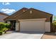 Single-story home featuring a two-car garage, desert landscaping, and a concrete driveway at 18147 W Ida Ln, Surprise, AZ 85387