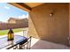 Covered outdoor patio with a table and chairs, next to a well-manicured lawn at 18147 W Ida Ln, Surprise, AZ 85387