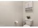 Cozy powder room features a decorative cabinet above toilet, plus toilet paper rack at 18147 W Ida Ln, Surprise, AZ 85387