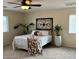 Well-lit bedroom features neutral carpet, a ceiling fan and leafy plants creating a cozy atmosphere at 1232 E Strawberry Dr, Gilbert, AZ 85298