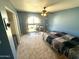 Serene blue bedroom featuring carpet, a ceiling fan, and a workspace with natural light at 225 N Standage -- # 102, Mesa, AZ 85201
