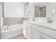 A Primary bathroom featuring double sinks, a soaking tub, and gray subway tile at 5338 W Manzanita Dr, Glendale, AZ 85302