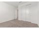 A bright bedroom with neutral carpet, natural light, and a closet for storage at 5338 W Manzanita Dr, Glendale, AZ 85302