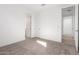 Carpeted bedroom with multiple doors and neutral walls at 5338 W Manzanita Dr, Glendale, AZ 85302