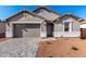 Charming single-story home with stone accents, gray trim, desert landscaping, and paved walkway to the front door at 5338 W Manzanita Dr, Glendale, AZ 85302