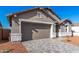 Attached two-car garage with a paved driveway, stone accents, gray trim, and desert landscaping at 5338 W Manzanita Dr, Glendale, AZ 85302