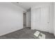 Bright bedroom with plush gray carpeting, an open doorway, and double closet doors at 5344 W Manzanita Dr, Glendale, AZ 85302