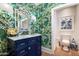 Stylish powder room with a blue vanity and green floral wallpaper at 5518 E Sanna St, Paradise Valley, AZ 85253