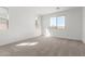 A naturally illuminated bedroom, featuring carpet floors and two windows providing outdoor views at 5332 W Manzanita Dr, Glendale, AZ 85302