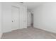 This carpeted bedroom has a closet and a doorway to another room at 5332 W Manzanita Dr, Glendale, AZ 85302