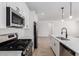 Bright kitchen featuring stainless steel appliances, white cabinets, a kitchen island and modern faucet at 5332 W Manzanita Dr, Glendale, AZ 85302