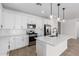 Modern kitchen with white cabinets, stainless steel appliances, an island with a sink and pendant lights at 5332 W Manzanita Dr, Glendale, AZ 85302