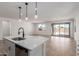 Modern kitchen island overlooks living space and features stainless steel dishwasher and modern pendant lighting at 5332 W Manzanita Dr, Glendale, AZ 85302