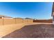 Large, undeveloped backyard enclosed by a brick wall, awaiting landscaping at 12322 W Marguerite Ave, Avondale, AZ 85323