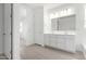 Bright bathroom featuring a double vanity, white cabinets, and tile flooring at 12322 W Marguerite Ave, Avondale, AZ 85323