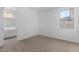 Bedroom featuring neutral carpet, a window, and a glimpse of the attached bath at 12322 W Marguerite Ave, Avondale, AZ 85323