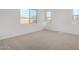 Cozy bedroom with carpet flooring and two windows providing natural light at 12322 W Marguerite Ave, Avondale, AZ 85323