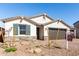 Charming home exterior featuring a two-car garage and desert landscaping at 12322 W Marguerite Ave, Avondale, AZ 85323