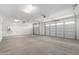 Spacious two car garage with two garage doors, water heater, and concrete flooring at 12322 W Marguerite Ave, Avondale, AZ 85323