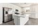 Bright kitchen featuring sleek white cabinetry, stainless steel appliances, and a large island with quartz countertops at 12326 W Marguerite Ave, Avondale, AZ 85323