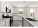 Bright kitchen showcasing white cabinets, stainless steel appliances, quartz counters, and tile flooring at 12326 W Marguerite Ave, Avondale, AZ 85323
