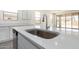 Modern kitchen island sink with stainless steel faucet, dishwasher, and white quartz countertops at 12326 W Marguerite Ave, Avondale, AZ 85323