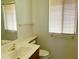 Bright bathroom with a vanity, toilet, and window with blinds at 10509 W Tropicana Cir, Sun City, AZ 85351