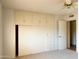 Bedroom with built in storage cabinets and sliding closet doors at 10509 W Tropicana Cir, Sun City, AZ 85351