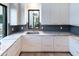 Modern kitchen with white cabinets, stainless steel sink, and granite countertops at 6850 E Joshua Tree Ln, Paradise Valley, AZ 85253