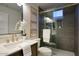 A bathroom featuring a shower with glass doors and modern fixtures, alongside a vanity with white countertops at 11566 E Christmas Cholla Dr, Scottsdale, AZ 85255