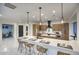 Bright, open kitchen featuring a large island with seating, modern appliances, and stylish pendant lighting at 11566 E Christmas Cholla Dr, Scottsdale, AZ 85255